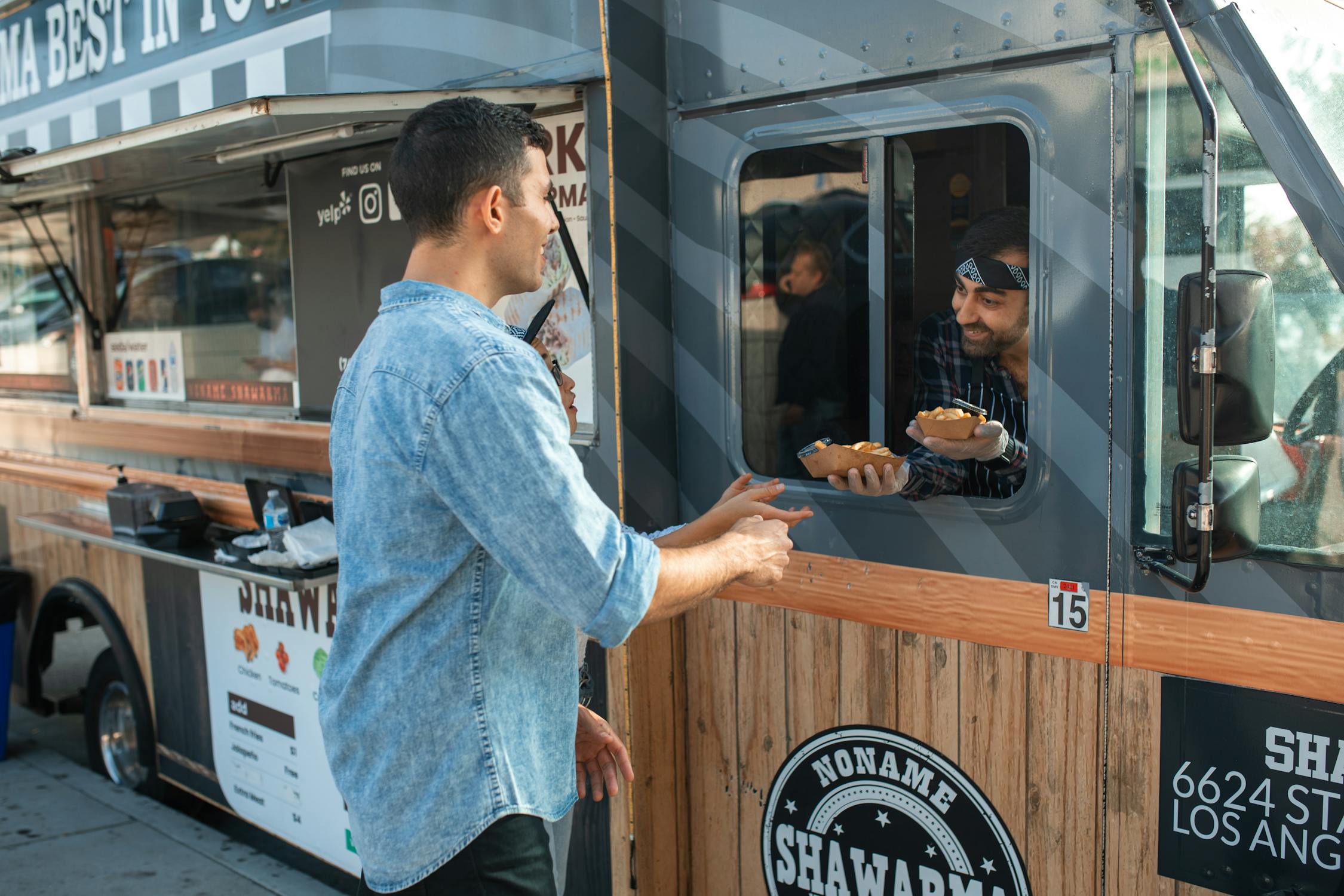 Food truck owner handing order directly to customer
