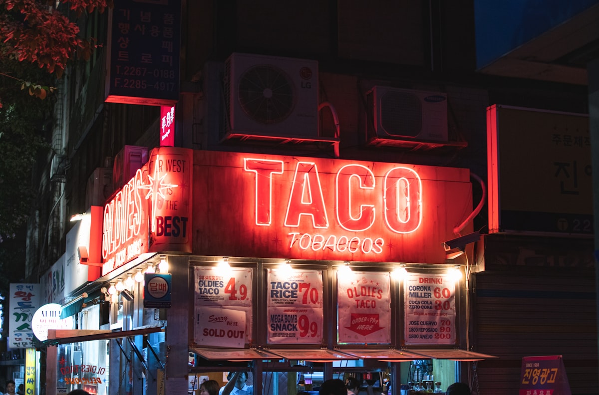Taco stand glowing at night on a city street